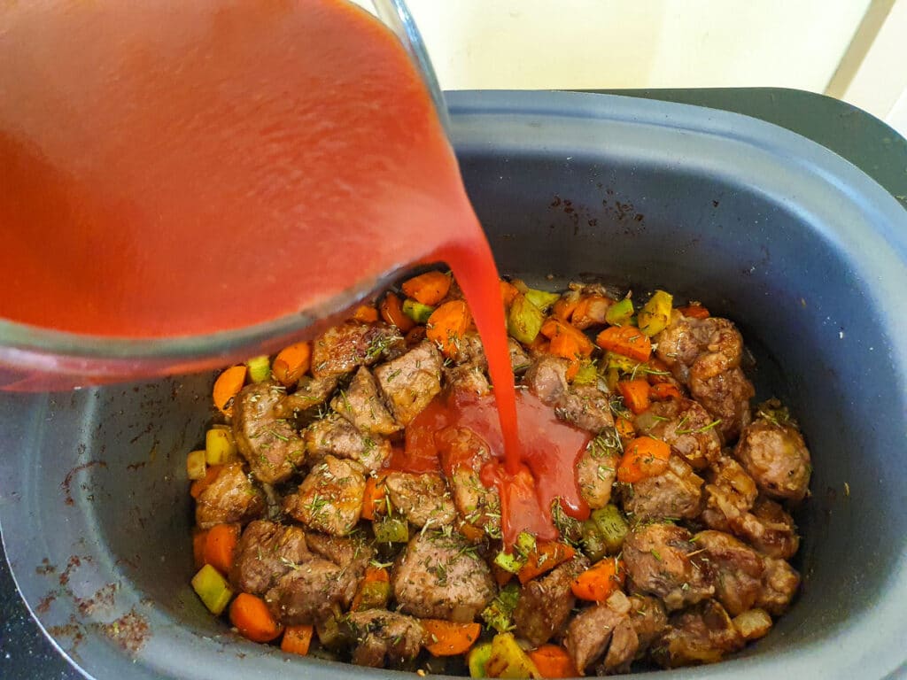 Pouring sauce over other ingredients.