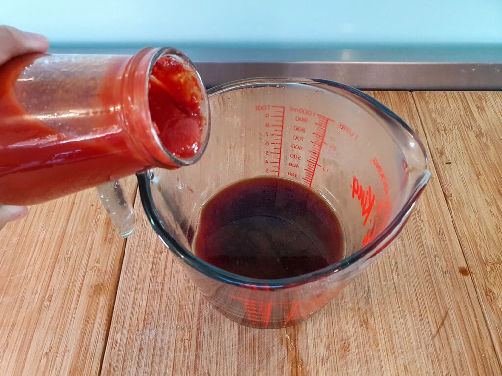 Adding passata to sauce.