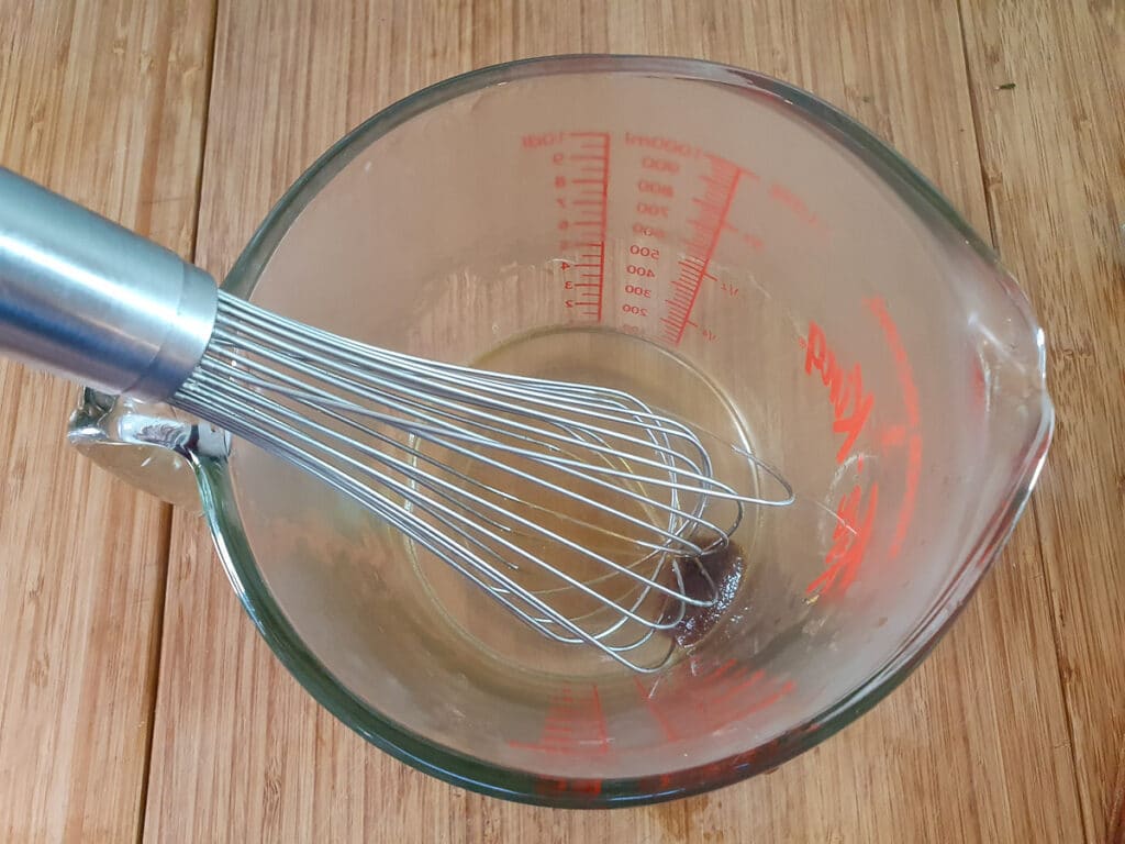 Whisking stock cube in boiling water to dissolve.