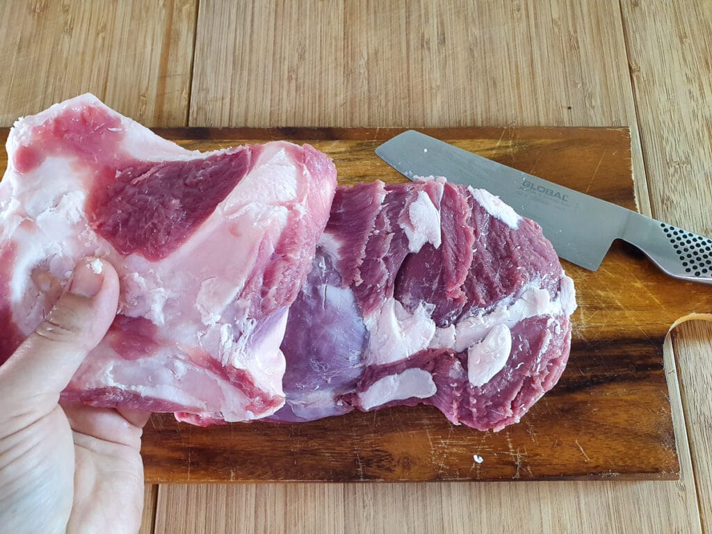 Removing the fat from the lamb.