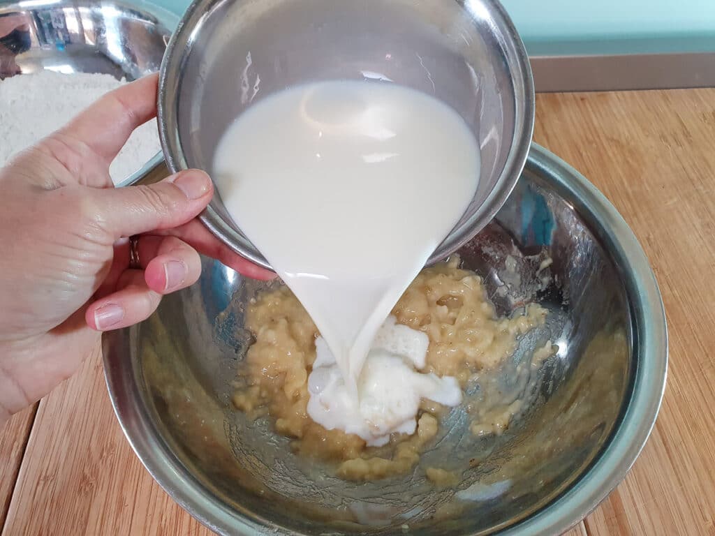 Adding milk to mashed banana.