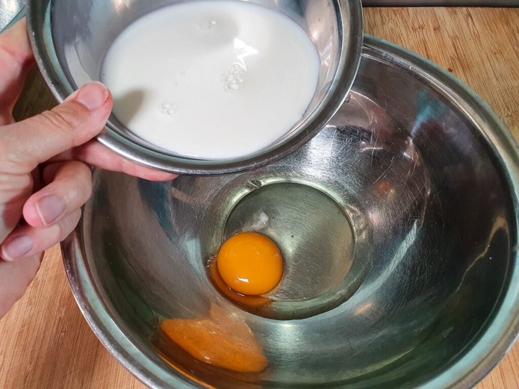 Adding milk to egg.