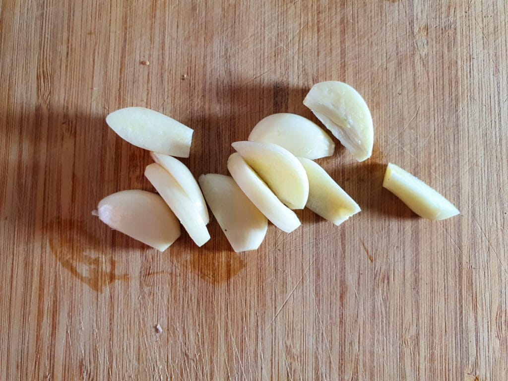 Chunky slivers of peeled garlic cloves ready to insert into lamb.
