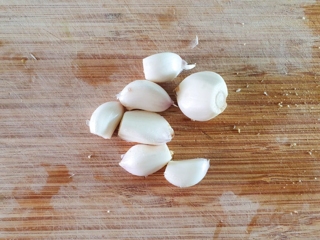 Peel and crush the garlic cloves.