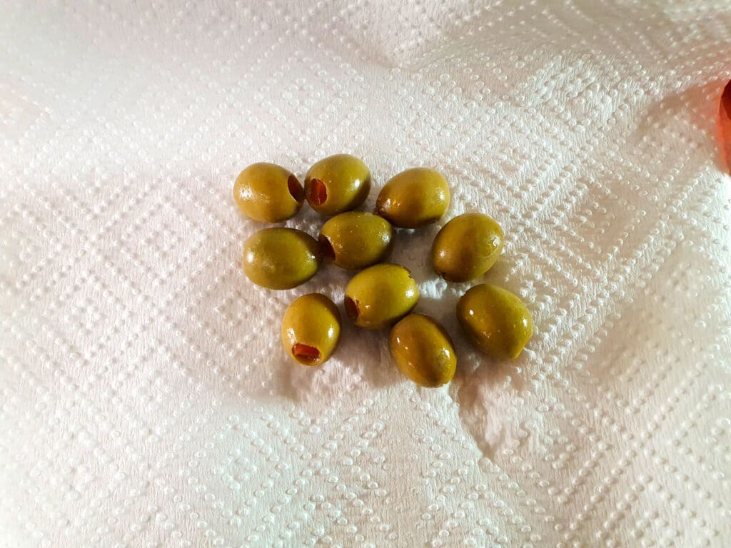 Patting dry green olives.