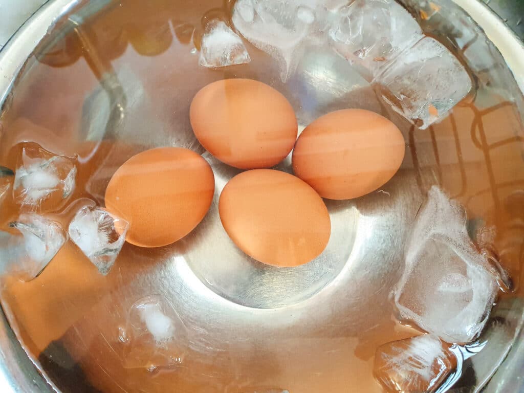 Cooling cooked eggs in ice water.