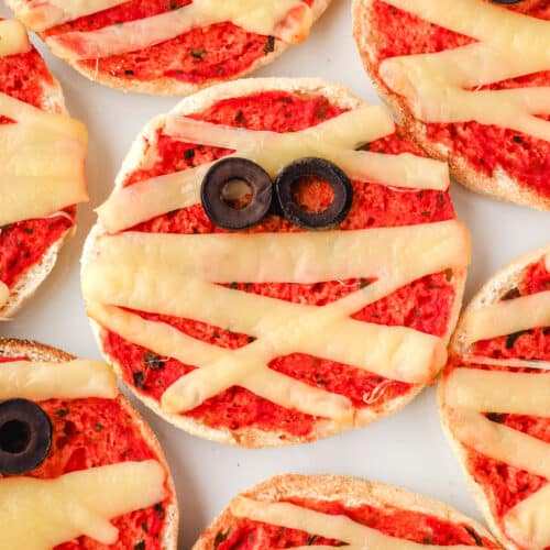 Top down view of mummy pizzas on a plate.